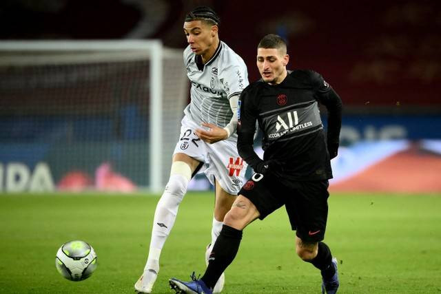 Pemain Paris Saint-Germain (PSG) Marco Verratti berusaha melewati pemain Reims pada pertandingan lanjutan Liga Prancis di stadion Parc des Princes, Paris, Prancis, Senin (24/1/2022).  Foto: FRANCK FIFE / AFP