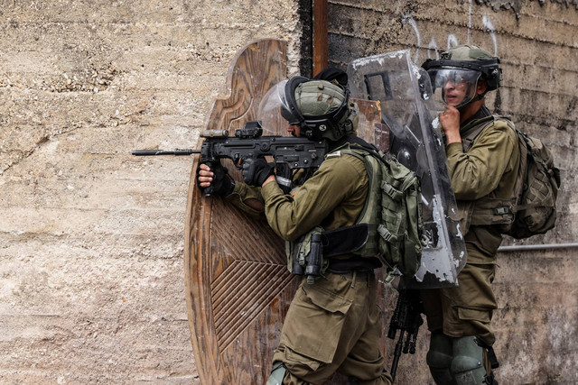 Tentara Israel dikerahkan di tengah bentrokan dengan demonstran Palestina saat protes terhadap pengambilalihan tanah Palestina oleh Israel di desa Kfar Qaddum di Tepi Barat, pada Jumat (7/10/2022). Foto: Ronaldo Schemidt/AFP