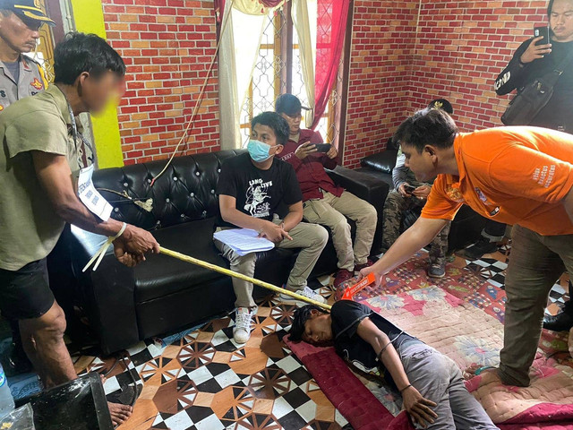 Tersangka Erwin memperagakan adegan pembunuhan terhadap Juwanda. | Foto: Polres Way Kanan