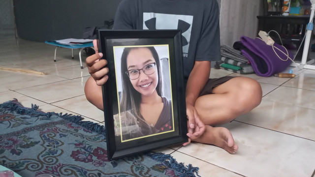 Adik WNI korban penembakan di Texas saat memegangi foto kakaknya.
Foto: Intan Alliva Khansa/kumparan
