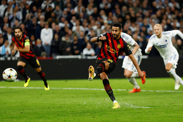 Pemain Manchester City Riyad Mahrez menendang penalti ke gawang FC Kopenhagen pada pertandingan Grup G Liga Champions di Parken, Kopenhagen, Denmark. Foto: Andrew Boyers/REUTERS