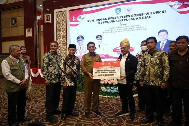 Tim Komisi VIII DPR RI menyerahkan bantuan secara simbolis kepada Gubernur Kepri, Ansar Ahmad (Foto: ist)