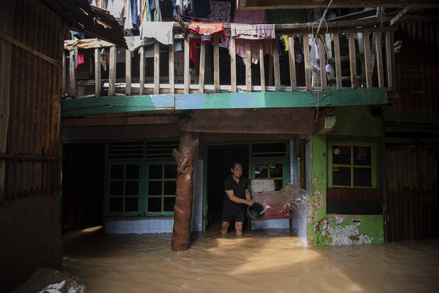 Ilustrasi warga membersihkan lumpur saat banjir. Foto: Sigid Kurniawan/Antara Foto