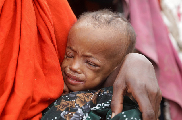 Buney Aayow Ibrahim, seorang wanita Somalia yang terkena dampak kekeringan yang memburuk, menggendong anaknya Sadia Salas Abdi (3) i kamp Alla Futo, di pinggiran Mogadishu, Somalia, Jumat (23/9/2022). Foto: Feisal Omar/Reuters