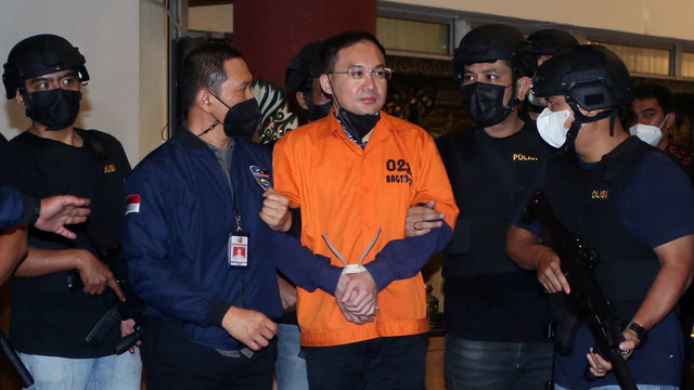 Petugas kepolisian membawa tersangka bandar besar judi online Apin Bak Kim alias Apin BK setibanya dari Malaysia di Bandara Soekarno Hatta, Tangerang, Banten, Jumat (14/10/2022). Foto: Muhammad Iqbal/ANTARA FOTO