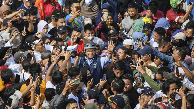 Gubernur DKI Jakarta Anies Baswedan (tengah) melambaikan tangan saat bersepeda pada Hari Bebas Kendaraan Bermotor (HBKB) di kawasan Bundaran Hotel Indonesia (HI), Jakarta, Minggu (16/10/2022). Foto: ANTARA FOTO/M Risyal Hidayat