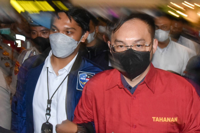 Polisi membawa tersangka bandar judi online Apin BK (kedua kiri) saat tiba di Bandara Kualanamu, Deli Serdang, Sumatera Utara, Senin (17/10/2022). Foto: Fransisco Carolio/ANTARA FOTO