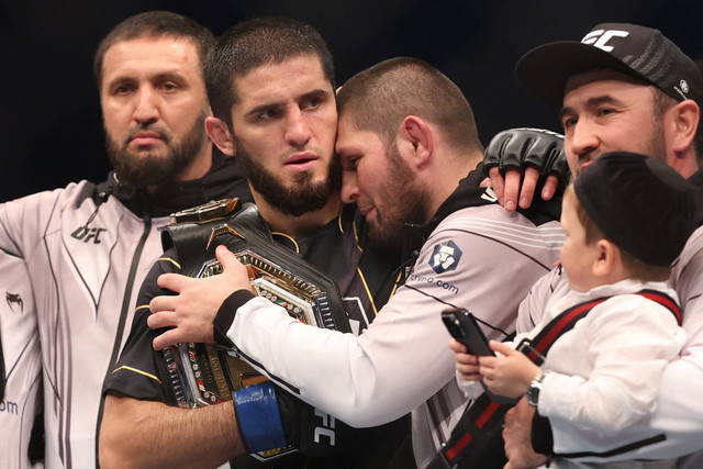 Islam Makhachev merayakan kemenangannya bersama Khabib Nurmagomedov usai melawan Charles Oliveira pada Minggu (23/10/2022). Foto: Christopher Pike/REUTERS