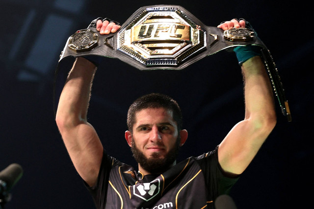 Islam Makhachev merayakan dengan sabuk juara setelah memenangkan pertarungannya melawan Charles Oliveira pada UFC 280 di Etihad Arena, Abu Dhabi, Uni Emirat Arab, Minggu (23/10/2022). Foto: Christopher Pike/REUTERS