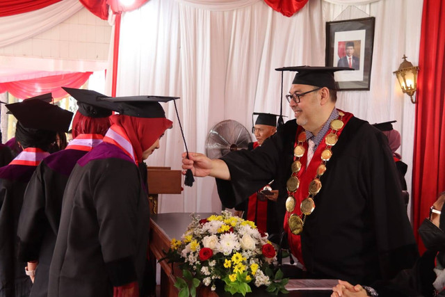 Ketua STIE Malangkucecwara (ABM) Drs Bunyamin MM PhD mengukuhkan salah satu wisudawati. Foto / dok STIE Malangkucecwara