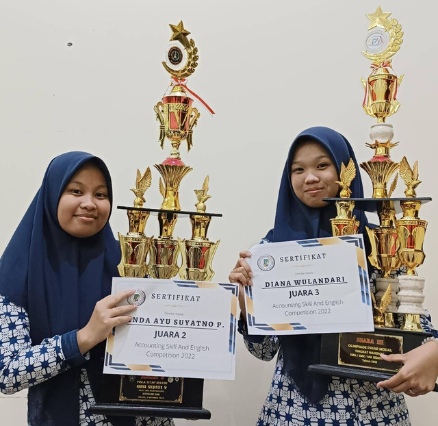 Kedua siswa membawa piala dan sertifikat lomba ASEC yang diselenggarakan Polinema. Foto / dok SMKN 1 Turen