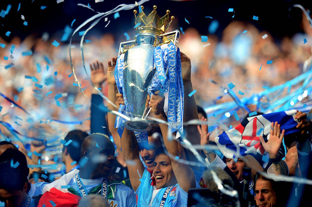 Pencetak gol penentu kemenangan Sergio Aguero dari Manchester City merayakan dengan trofi selama pertandingan Barclays Premier League antara Manchester City dan Queens Park Rangers di Stadion Etihad pada 13 Mei 2012. Foto: Shaun Botterill/Getty Images
