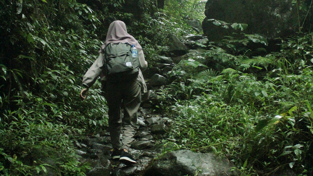 Tika Nuristiana melewati jalur setapak menuju ke Curug Lawe | Foto: Fakhrotun Nisa'