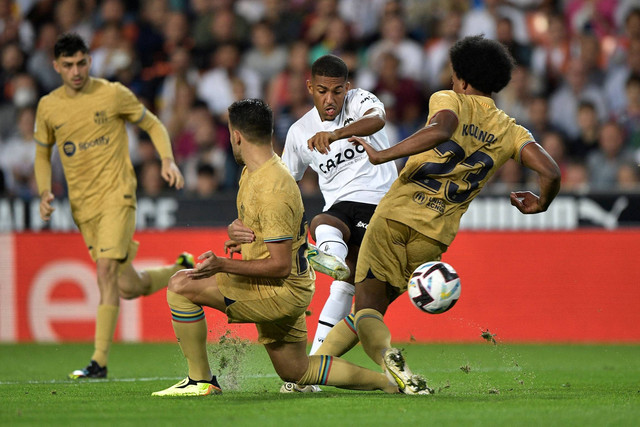 Pemain Valencia Samuel Lino beraksi bersama pemain FC Barcelona Jules Kounde di Stadion Mestalla, Valencia, Spanyol, Sabtu (29/10/2022). Foto: Pablo Morano/REUTERS