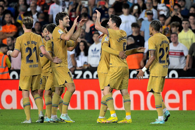 Pemain FC Barcelona Robert Lewandowski merayakan gol pertamanya dengan rekan setimnya di Stadion Mestalla, Valencia, Spanyol, Sabtu (29/10/2022). Foto: Jose Jordan/AFP