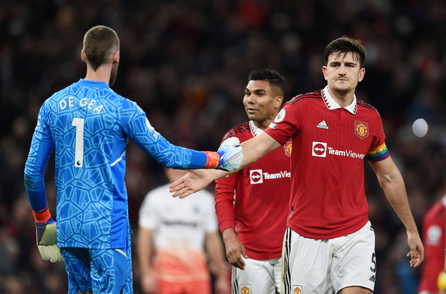 Pemain Manchester United David de Gea berjabat tangan dengan Harry Maguire pada babak pertama saat pertandingan di Old Trafford, Manchester, Inggris. Foto: Peter Powell/Reuters