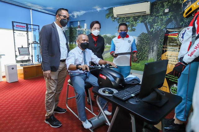 Ketua Yayasan Astra Honda Motor Ahmad Muhibbuddin ditemani Kepala Sekolah SMK Mitra Industri MM2100 Lispiyatmini melihat salah satu peserta pelatihan Wisata Edukasi Satu Hati sedang belajar keselamatan menggunakan Honda Riding Trainer (HRT) di Zona Audio-visual Safety Riding Lab Astra Honda. Foto: Astra Honda Motor