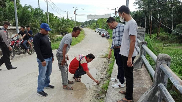 Noi (kaos abu-abu tanpa masker) saat rekontruksi pertama di Jembatan Desa Sukarjo Mesim, Kecamatan Rupat, Kabupaten Bengkalis, Riau. (DEFRI CANDRA/SELASAR RIAU)