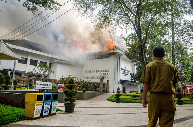 Seorang aparatur sipil negara menyelamatkan barang-barang dari lokasi kebakaran gedung Pemerintah Kota (Pemkot) Bandung di Balai Kota Bandung, Jawa Barat, Senin (7/11/2022). Foto: Novrian Arbi/ANTARA FOTO