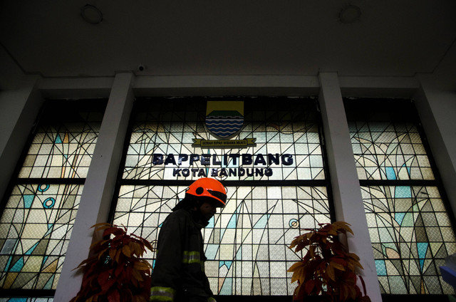 Petugas pemadam kebakaran berjalan usai proses pendinginan usai gedung Bappelitbang di kawasan perkantoran Pemkot Bandung, Balai Kota Bandung, Jawa Barat, Senin (7/11/2022). Foto: Novrian Arbi/Antara Foto