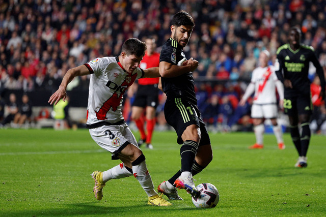 Pemail Real Madrid Marco Asensio berebut bola dengan pemain Rayo Vallecano pada pertandingan lanjutan Liga Spayol di Campo de Futbol de Vallecas, Madrid, Spanyol. Foto: Susana Vera/REUTERS