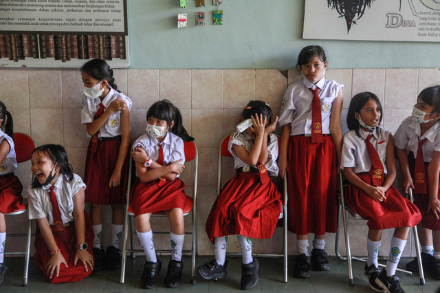 Sejumlah siswa menunggu giliran untuk disuntik vaksin saat kegiatan bulan imunisasi anak sekolah (BIAS) di SDS Santa Maria, Palangka Raya, Kalimantan Tengah, Selasa (8/10/2022). Foto: Makna Zaezar/Antara Foto