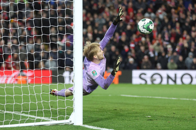 Penjaga gawang Liverpool Caoimhin Kelleher melakukan penyelamatan dalam adu penalti melawan Derby County pada pertandingan babak ketiga ketiga Piala Carabao di Anfield, Liverpool, Inggris. Foto: Carl Recine/REUTERS
