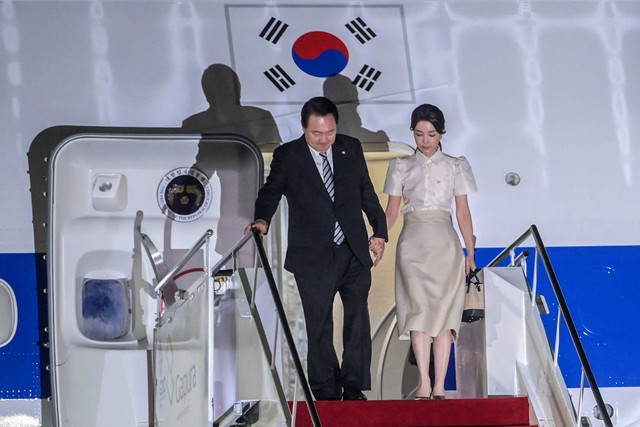 Presiden Korea Selatan Yoon Suk-yeol (kiri) bersama istri Kim Keon Hee (kanan) tiba di terminal VVIP I Bandara I Gusti Ngurah Rai Bali, Minggu (13/11/2022). Foto: Galih Pradipta/Antara Foto