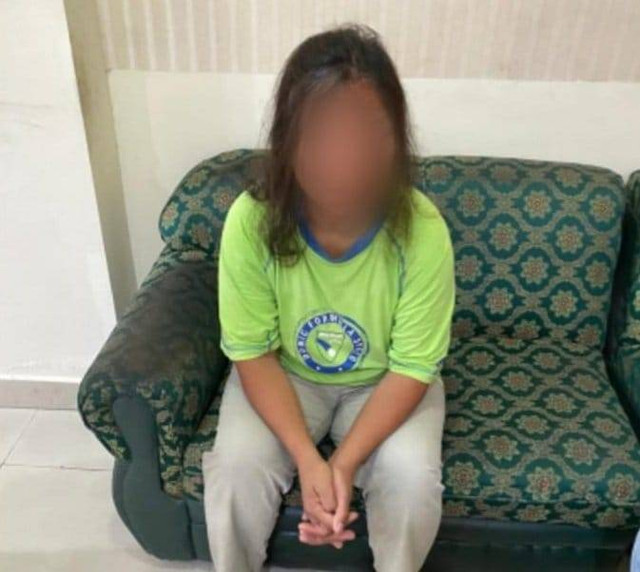 Perempuan yang akan bentang spanduk di Nusa Dua saat diamankan polisi - IST