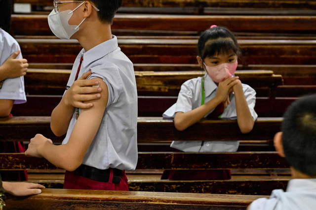 Siswa menerima vaksin difteri di sebuah sekolah dasar Kristen di Banda Aceh, Selasa (15/11/2022). Foto: Chaideer Mahyuddin/AFP