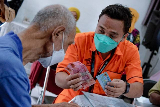 Warga menerima bantuan langsung tunai (BLT) bahan bakar minyak (BBM) di pos RW 01 Kelurahan Gambir, Jakarta Pusat, Jumat (2/9/2022). Foto: Jamal Ramadhan/kumparan