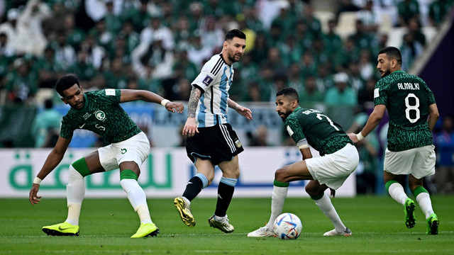 Pemain Timnas Argentina Lionel Messi berusaha melewati pemain Timnas Arab Saudi Ali Al Bulayhi dan Salman Al-Faraj pada pertandingan Grup C Piala Dunia 2022 Qatar di Stadion Lusail, Lusail, Qatar. Foto: Dylan Martinez/REUTERS