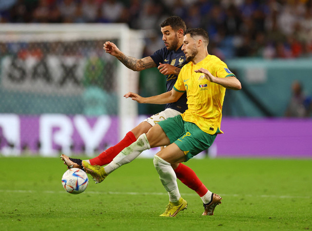 Theo Hernandez dari Prancis duel dengan Mathew Leckie dari Australia pada pertandingan Piala Dunia Qatar 2022 Grup D di Stadion Al Janoub, Al Wakrah, Qatar. Foto: Kai Pfaffenbach/Reuters