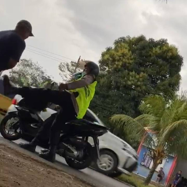 Terlihat polisi menendang sopir truk angkutan batu bara. (Foto: Istimewa)