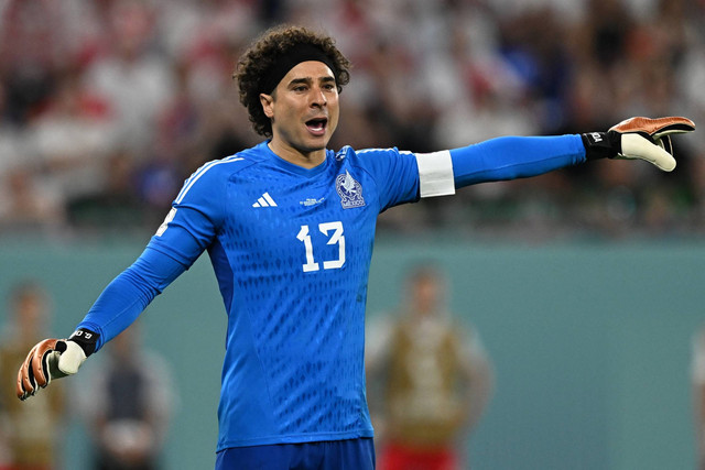 Penjaga gawang Meksiko Guillermo Ochoa memberi isyarat selama pertandingan sepak bola Grup C Piala Dunia Qatar 2022 antara Meksiko dan Polandia di Stadion 974 di Doha, Qatar, Selasa (22/11/2022). Foto: Manan VATSYAYANA/AFP