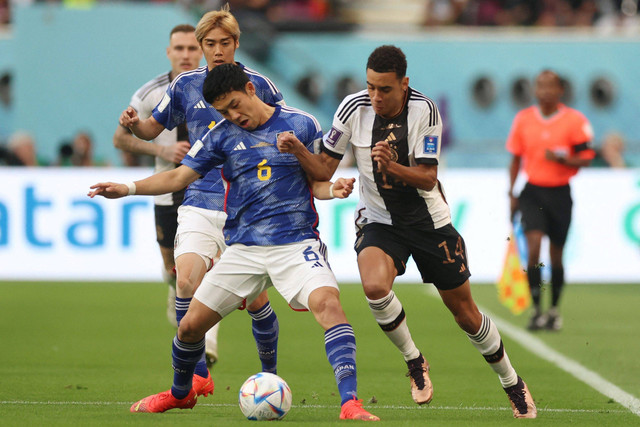 Pemain Timnas Jerman Jamal Musiala berebut bola dengan pemain Timnas Jepang Wataru Endo pada pertandingan Grup E Piala Dunia 2022 Qatar di Stadion Internasional Khalifa, Doha, Qatar. Foto: Lee Smith/REUTERS