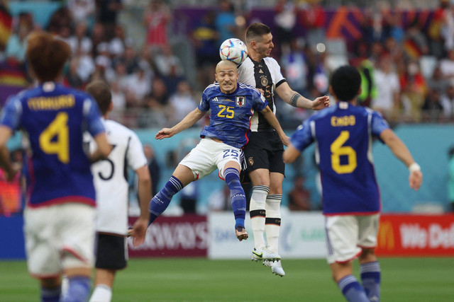 Pemain Timnas Jerman Niklas Sule berebut bola dengan pemain Timnas Jepang Daizen Maeda pada pertandingan Grup E Piala Dunia 2022 Qatar di Stadion Internasional Khalifa, Doha, Qatar. Foto: Lee Smith/REUTERS