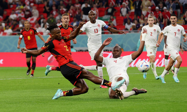 Michy Batshuayi dari Belgia duel dengan Kamal Miller dari Kanada  pada pertandingan Piala Dunia Qatar 2022 Grup F di Stadion Ahmad Bin Ali, Al Rayyan, Qatar. Foto: Matthew Childs/Reuters