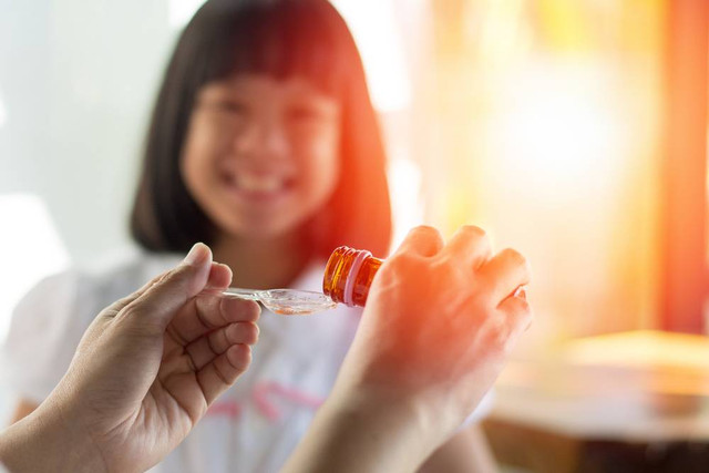 Ilustrasi memberikan obat sirop untuk anak. Foto: BlurryMe/Shutterstock