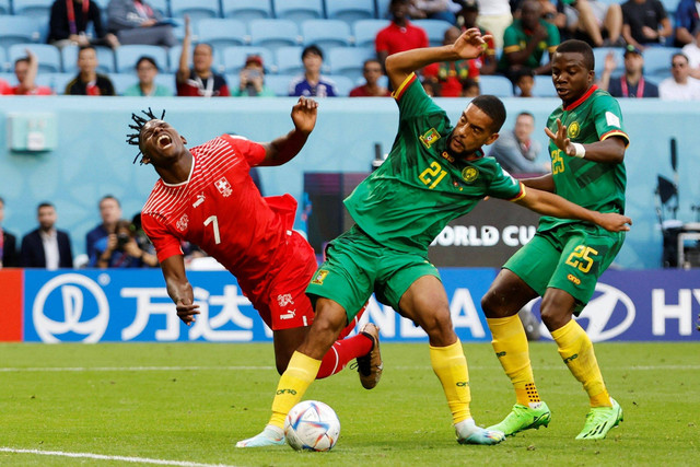 Pemain Timnas Swiss Breel Embolo berusaha melewati pemain Timnas Kamerun Nouhou Tolo dan Jean-Charles Castelletto pada pertandingan Grup G Piala Dunia 2022 Qatar di Stadion Al Janoub, Al Wakrah, Qatar Foto: Issei Kato/REUTERS