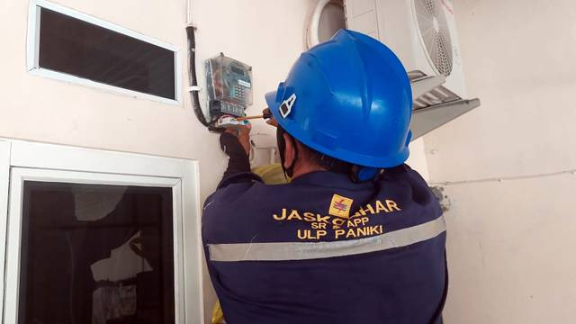 Petugas PLN saat melakukan pemasangan meteran listrik di rumah warga.