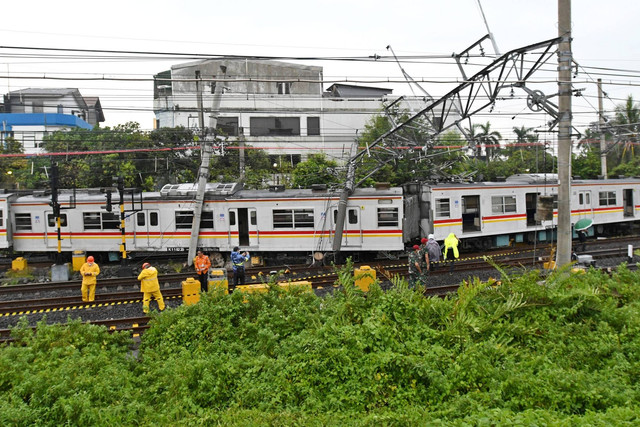 Sejumlah petugas berupaya mengevakuasi rangkaian kereta rel listrik (KRL) Commuterline KA 5144C yang anjlok dan tertimpa tiang listrik di perlintasan Stasiun Kampung Bandan, Jakarta, Sabtu (26/11/2022). Foto: Aditya Pradana Putra/ANTARA FOTO