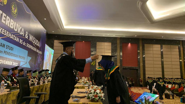 Rektor ITSK RS dr Soepraoen saat mengukuhkan salah seorang wisudawan. Foto / Feni Yusnia