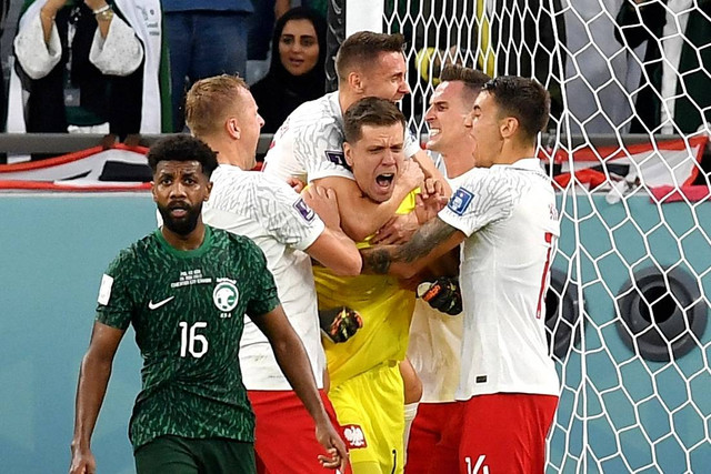 Kiper Polandia Wojciech Szczesny merayakan dengan rekan setimnya setelah menyelamatkan penalti dari Arab Saudi Salem Al-Dawsari, pada Piala Dunia 2022, di Education City Stadium, Al Rayyan, Qatar, sabtu (26/11/2022). Foto: Jennifer Lorenzini/REUTERS