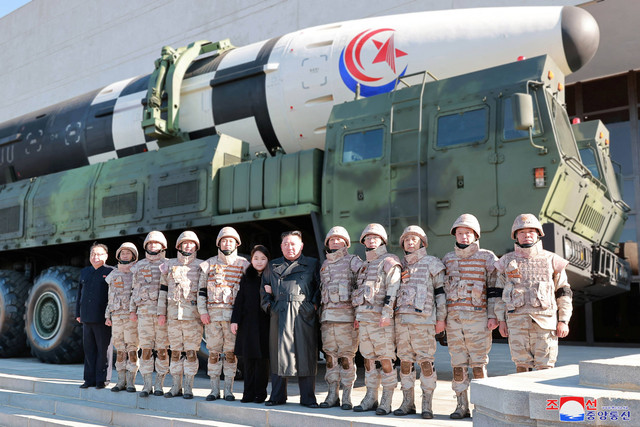 Pemimpin Korea Utara, Kim Jong Un dan putrinya menghadiri sesi foto dengan para ilmuwan, insinyur, dan pejabat militer dalam uji coba rudal balistik antarbenua (ICBM) Hwasong-17, dalam foto tak bertanggal yang rilis pada Minggu (27/11/2022). Foto: KCNA/via REUTERS