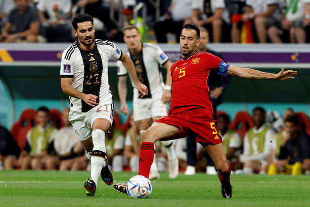 Pemain Timnas Spanyol Sergio Busquets berebut bola dengan pemain Timnas Jerman Ilkay Gundogan pada pertandingan Grup E Piala Dunia 2022 Qatar di Stadion Al Bayt, Al Khor, Qatar. Foto: Albert Gea/REUTERS