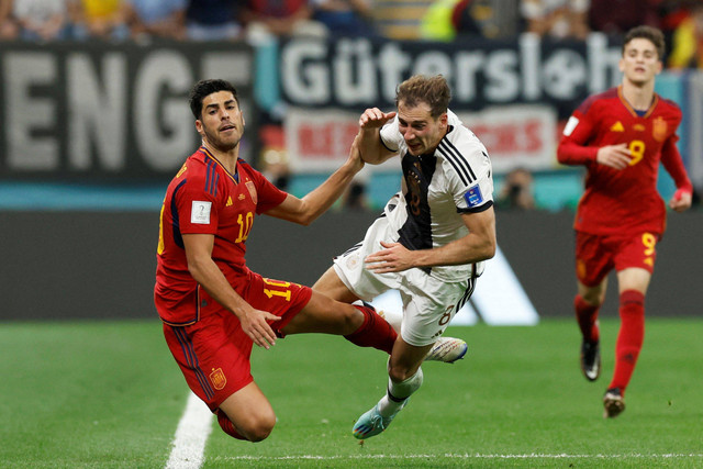 Pemain Timnas Spanyol Marco Asensio berebut bola dengan pemain Timnas Jerman Leon Goretzka pada pertandingan Grup E Piala Dunia 2022 Qatar di Stadion Al Bayt, Al Khor, Qatar. Foto: Albert Gea/REUTERS