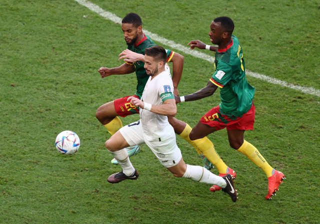 Dusan Tadic dari Serbia duel dengan pemain Kamerun Gael Ondoua dan Jean-Charles Castelletto pada pertandingan Piala Dunia Qatar 2022 Grup G di Stadion Al Janoub, Al Wakrah, Qatar. Foto: Marko Djurica/Reuters