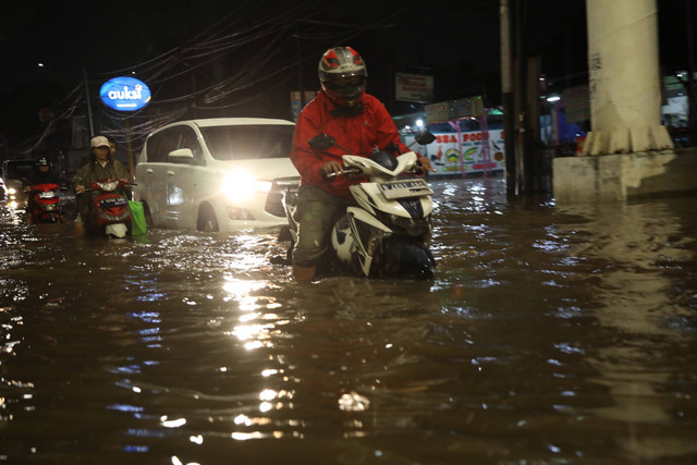 Sejumlah pengendara berusaha melintasi banjir di jalan Ciledug raya, Jakarta, Senin (28/11).  Foto: Aditia Noviansyah/kumparan
