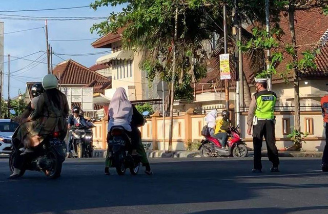 Pengendara sepeda motor di Kota Bandar Lampung tak menggunakan helm meskipun melewati polisi lalu lintas. | Foto: Lampung Geh